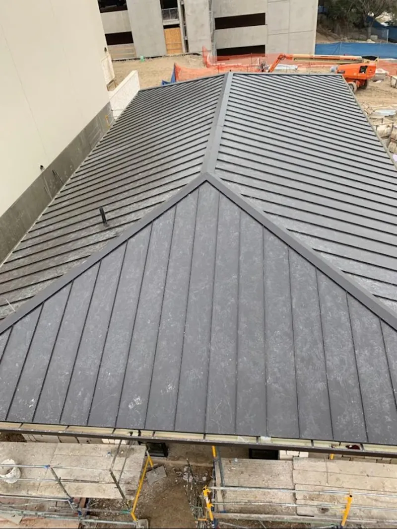 Commercial metal roof construction with crane equipment in Latrobe